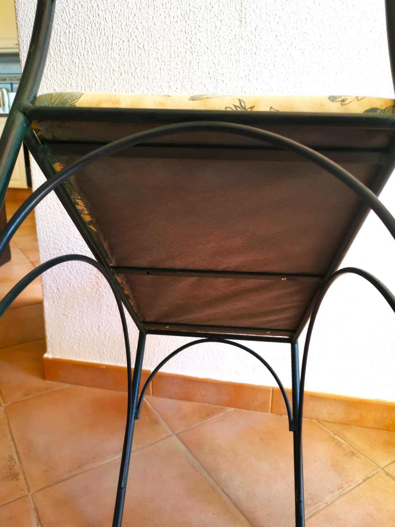 Assento com estrutura em ferro forjado e almofada fixa acolchoada.