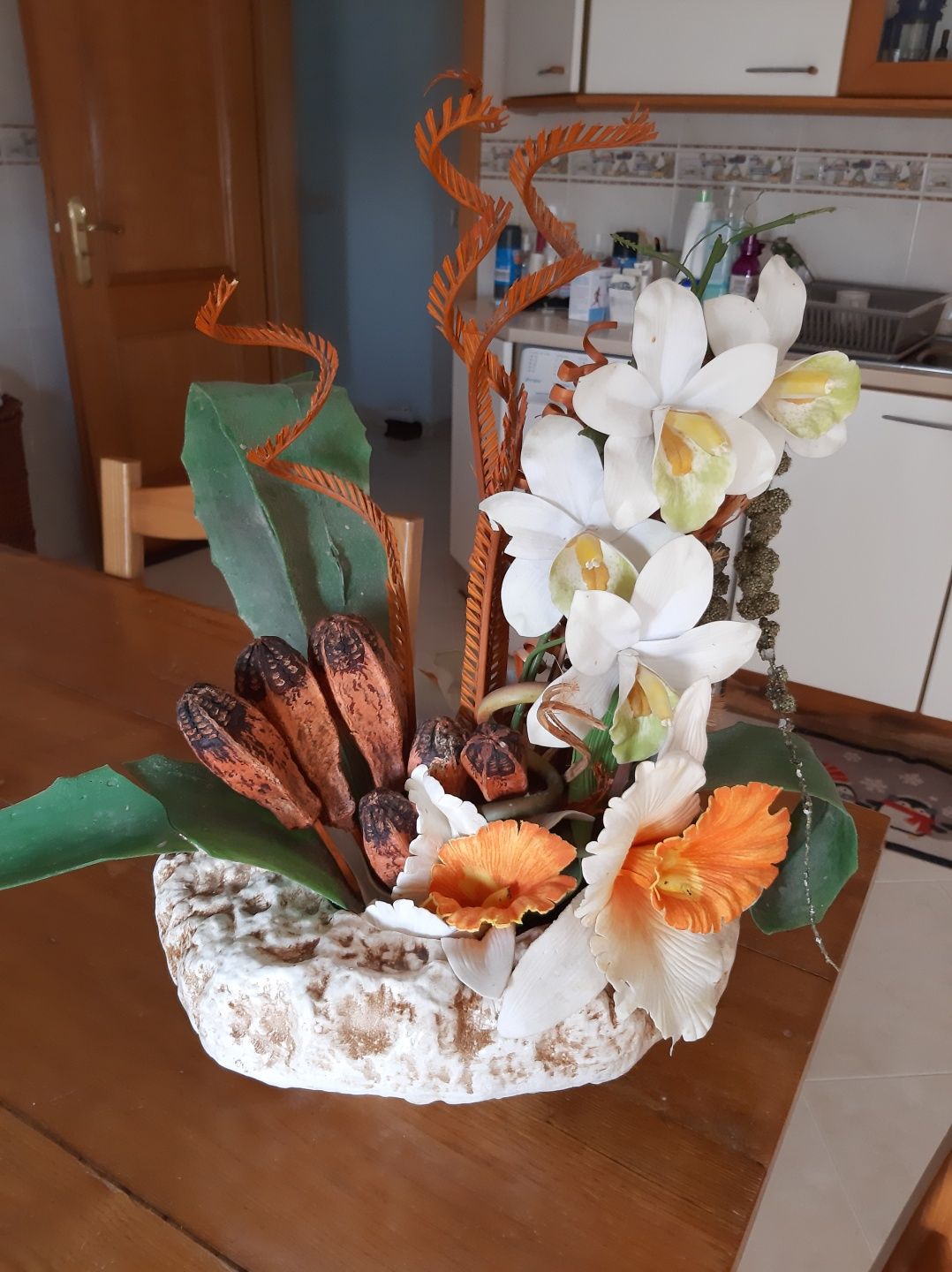 Arranjo decorativo com base em barro e flores artificiais