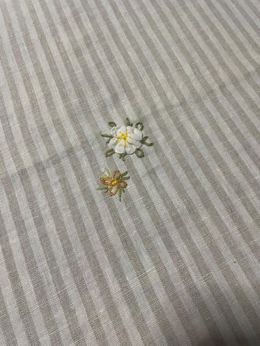 Toalha riscada em linho com bordado saliente .