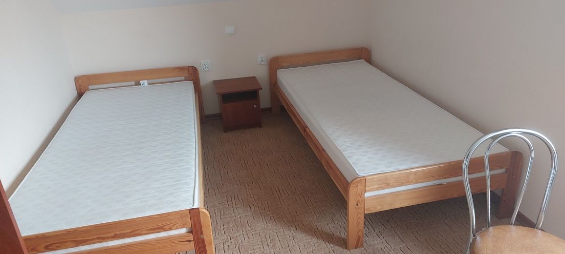 Łóżka drewniane, rozne odcienie, materace, szafki nocne
