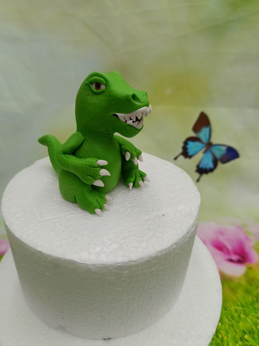 Kobieta i dinozaur z masy cukrowej na tort