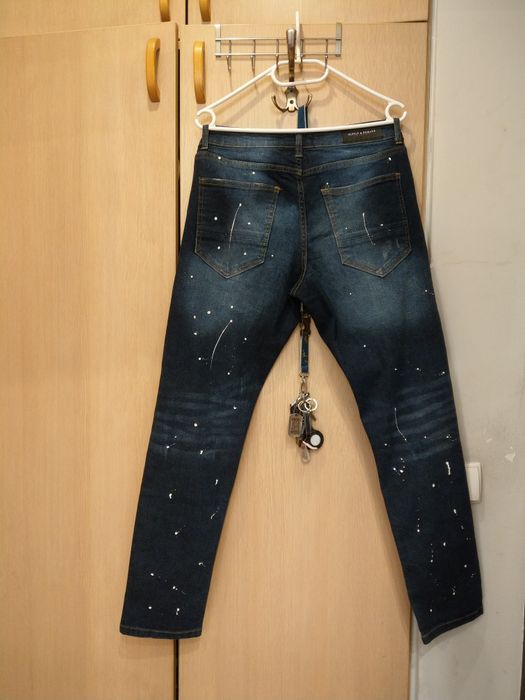 spodnie jeansowe z przetarciami dziurami i kropkami imitujacymi farbe