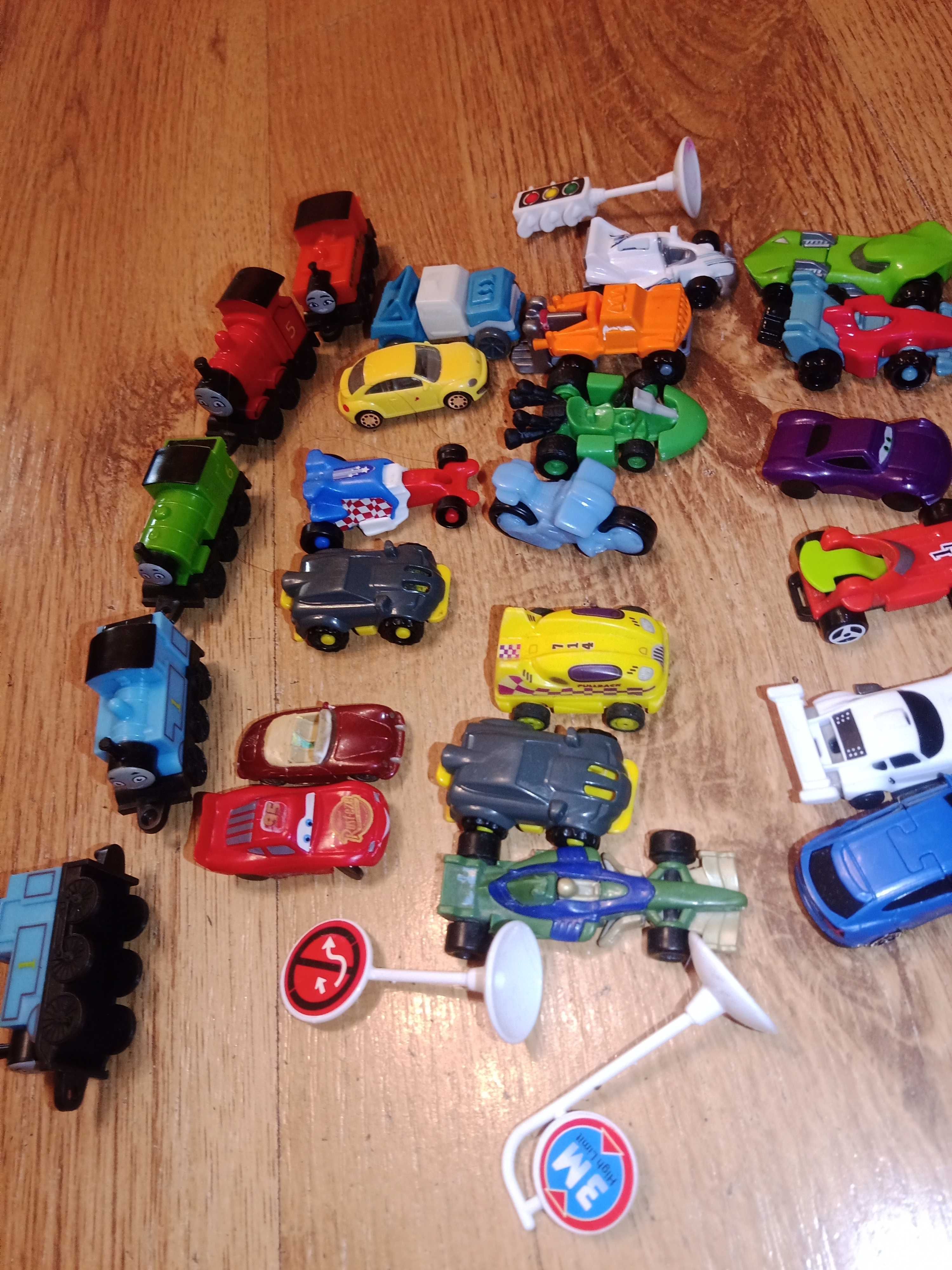 Małe plastikowe samochody i lokomotywy
