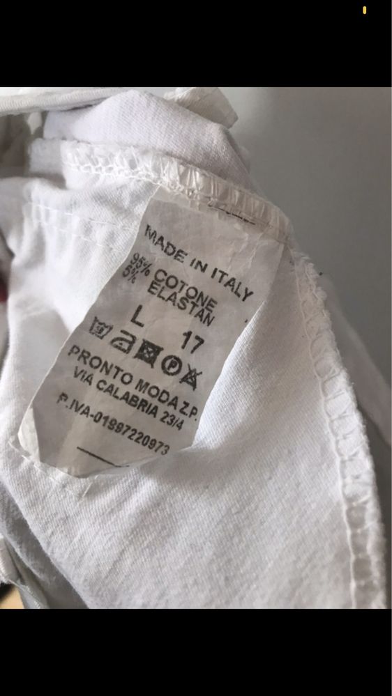 Białe spodnie jeansy z dziurami i poszarpanymi nogawkami