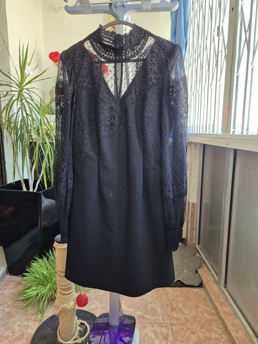 Vestido morgan preto com mangas rendadas.