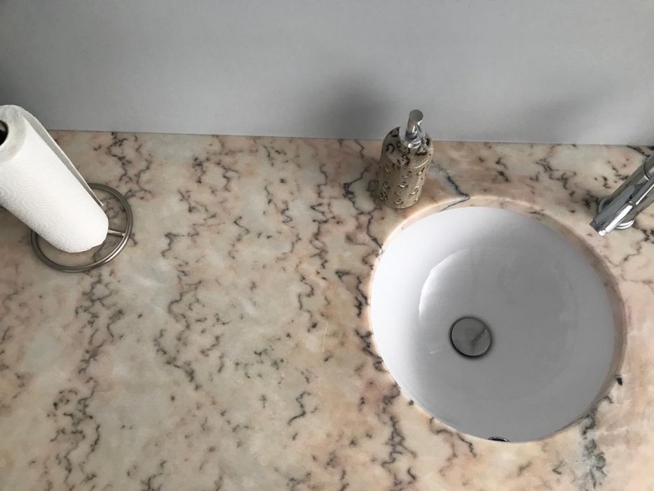 Bancada de mármore com lavatório e torneira