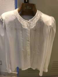Blusa branca tipo seda com manga comprida.