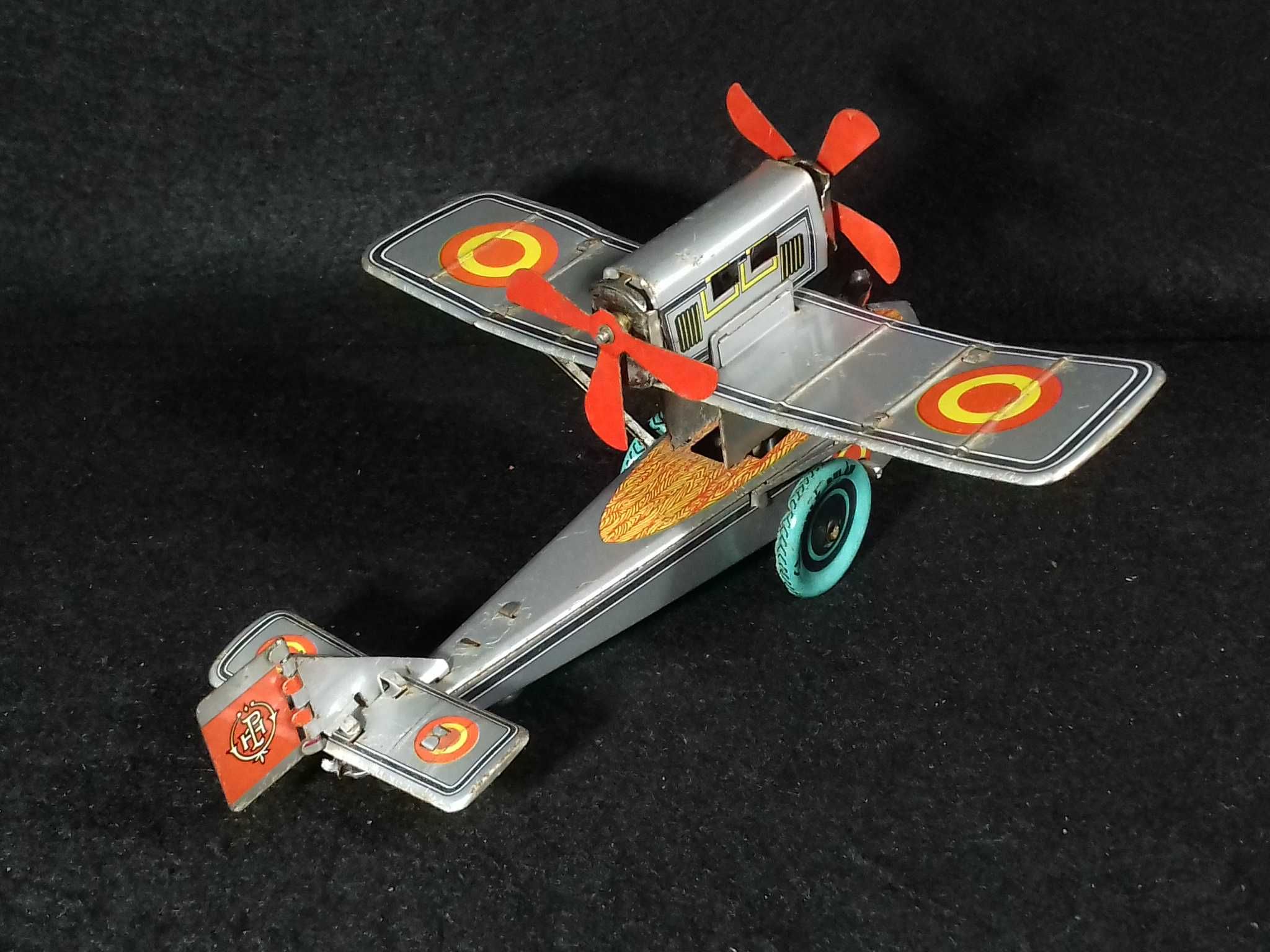 Miniatura de avião antigo em metal, com sistema mecânico de corda;