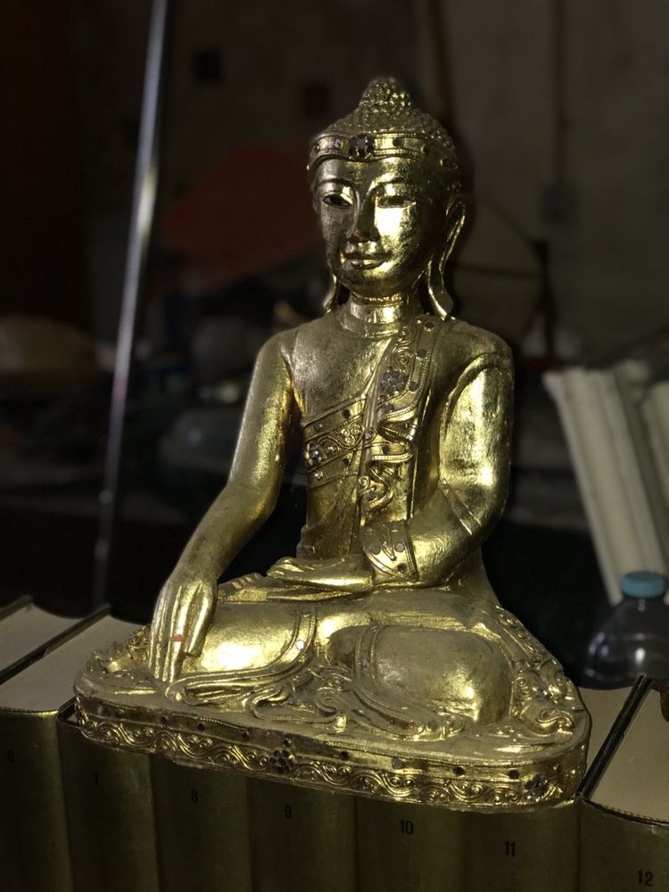 Buda antigo em madeira talhada e em folha de ouro