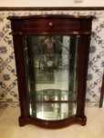 Móvel vitrine em mogno e portas com vidro e espelho no fundo.