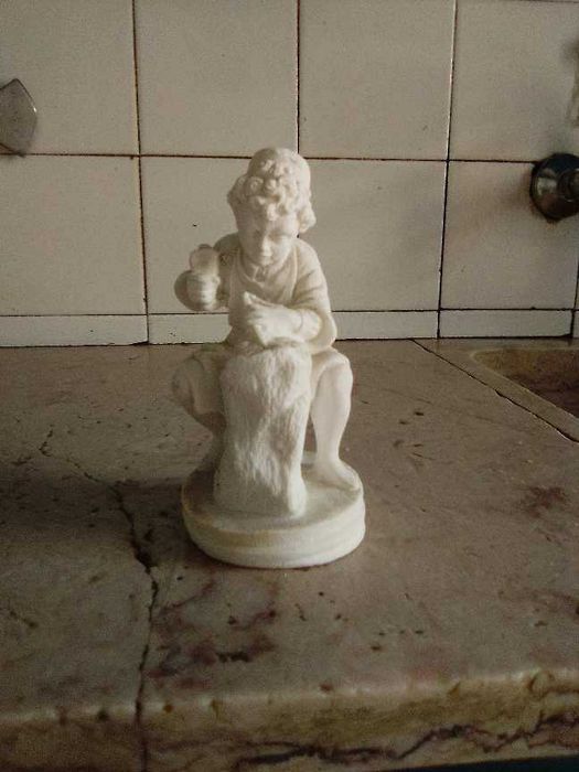 estatueta menino escultor