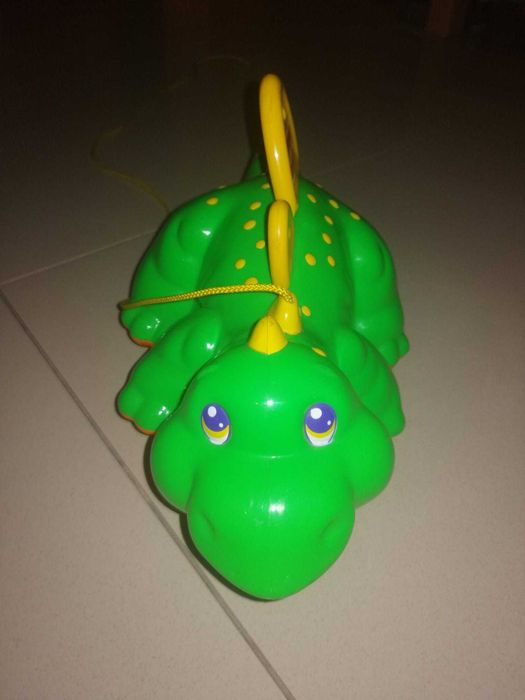 Dinossauro Playskool sobre rodas para criança