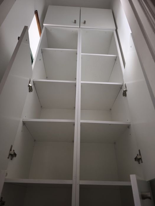 Armário branco com portas e prateleiras