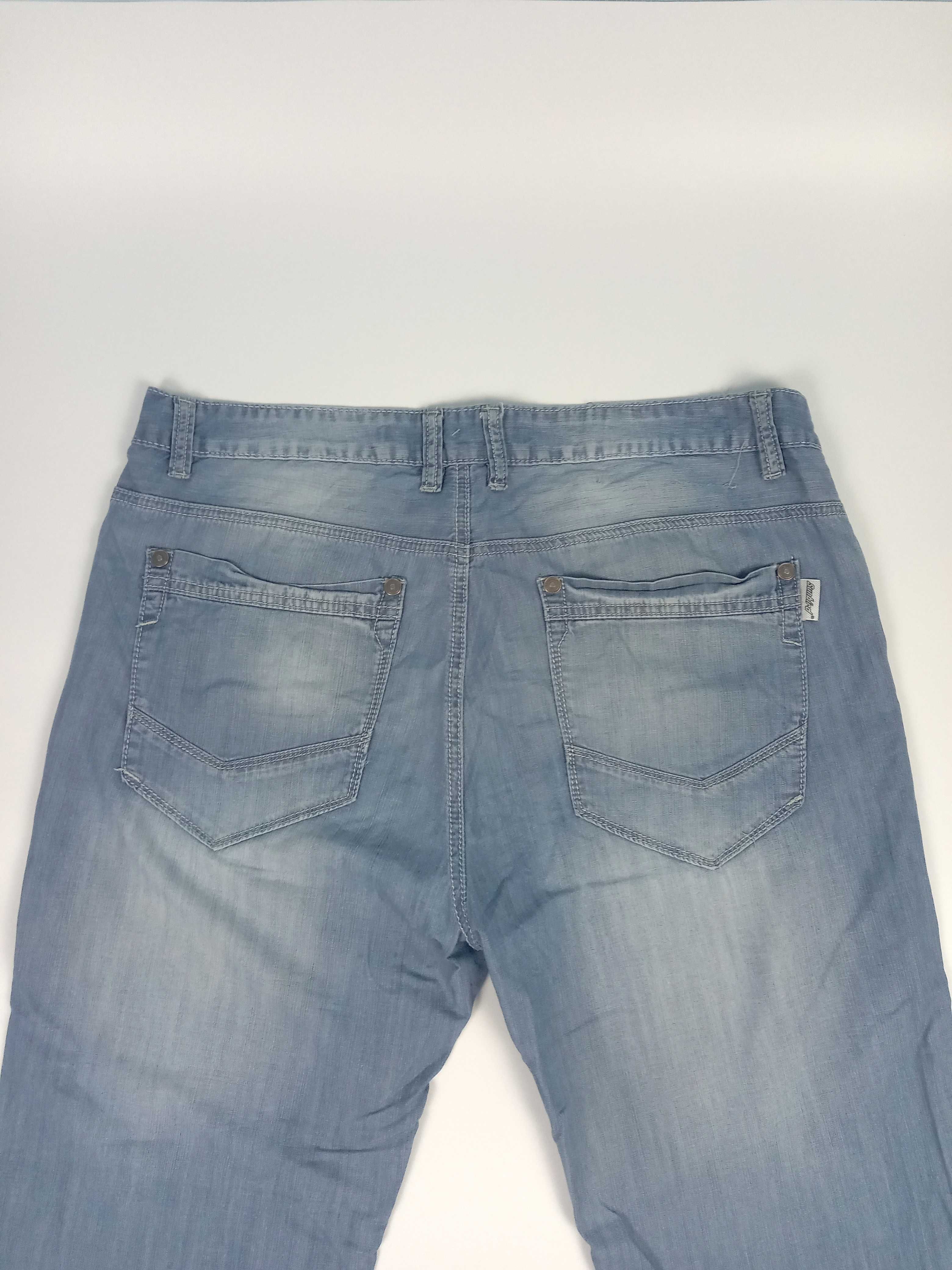 Jasno niebieskie cienkie jeansowe spodnie męskie z wybarwieniami r M/L