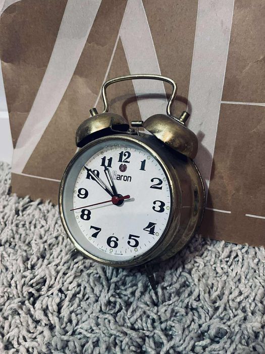 Piękny złoty budzik nakręcany na mechanizm zegar