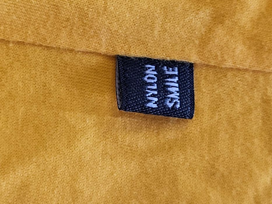 Żółta koszulka z kolekcji Nylon Smile, rozmiar M, nadrukiem bohaterów.