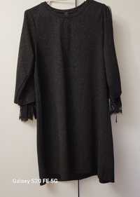 Czarna sukienka pokryta brokatem z koronką przy rękawach