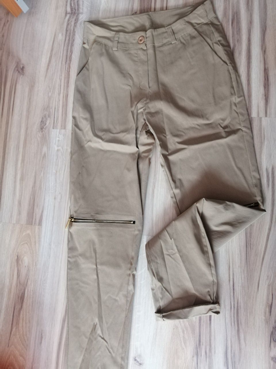 Nowe bezowe spodnie z zameczkami rozcięcia na kolanach S/M