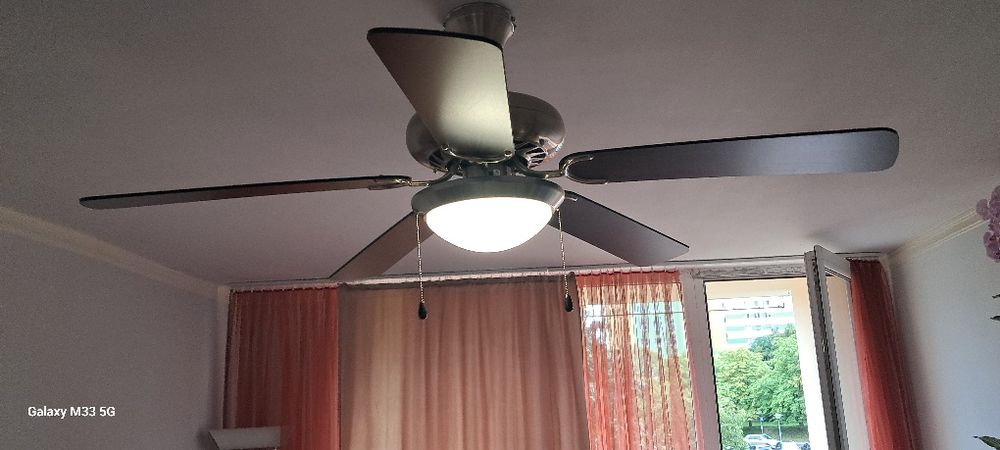 Wentylator wiatrak sufitowy z żyrandolem/lampą.