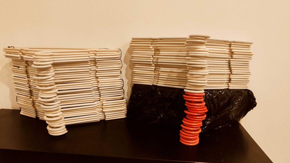 Cabides plásticos brancos e cor-de-rosa