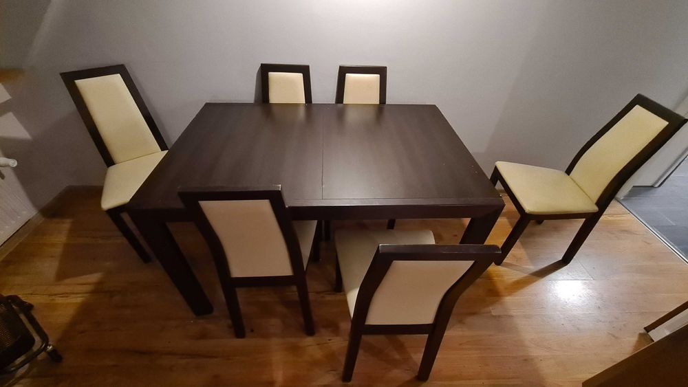 Brązowy rozkładany stół z 6 białymi krzesłami