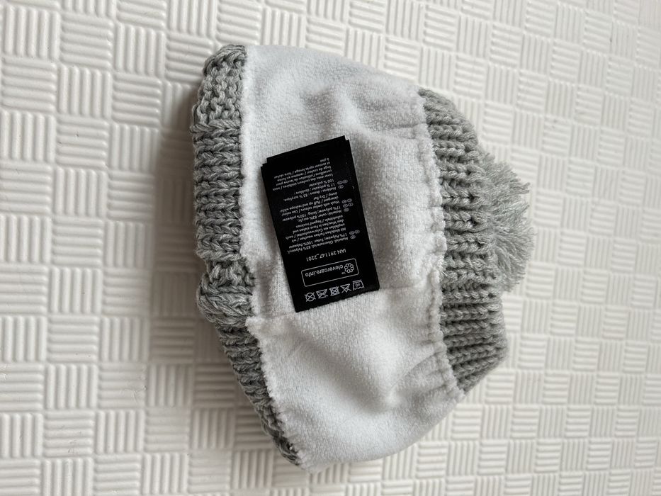 Вʼязана зимова жіноча шапка з помпоном сірого кольору