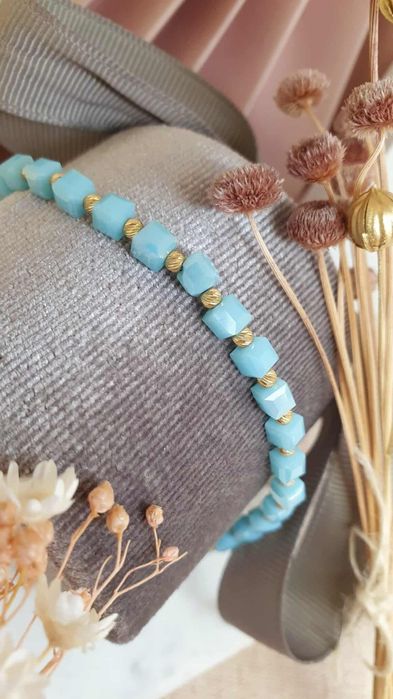 Bransoletka na sznureczku z niebieskimi koralikami.i I złotymi kulkami