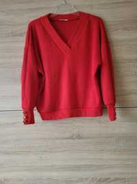 Czerwony sweter z guzikami na rękawach