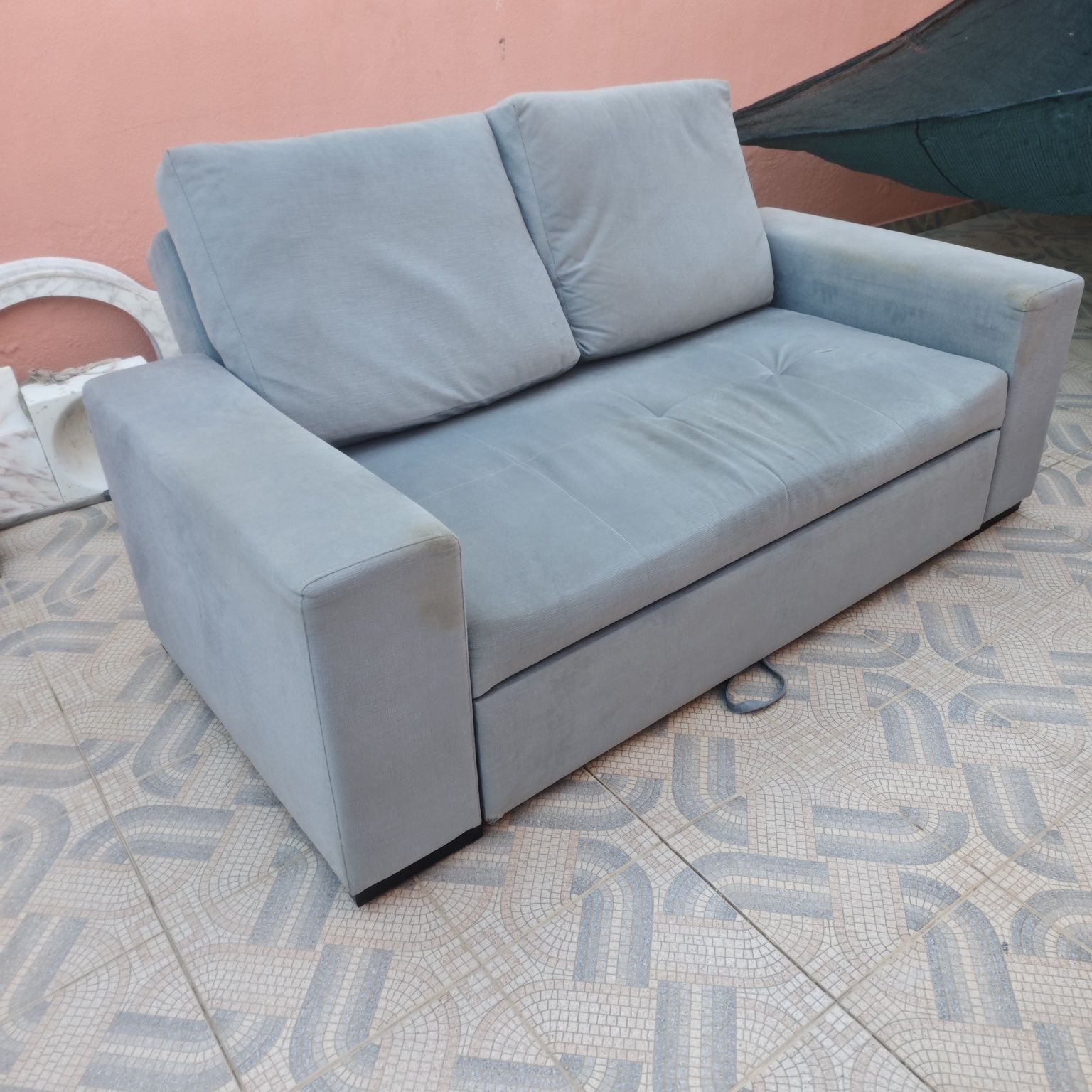 Sofá cinzento que se transforma em cama de gaveta