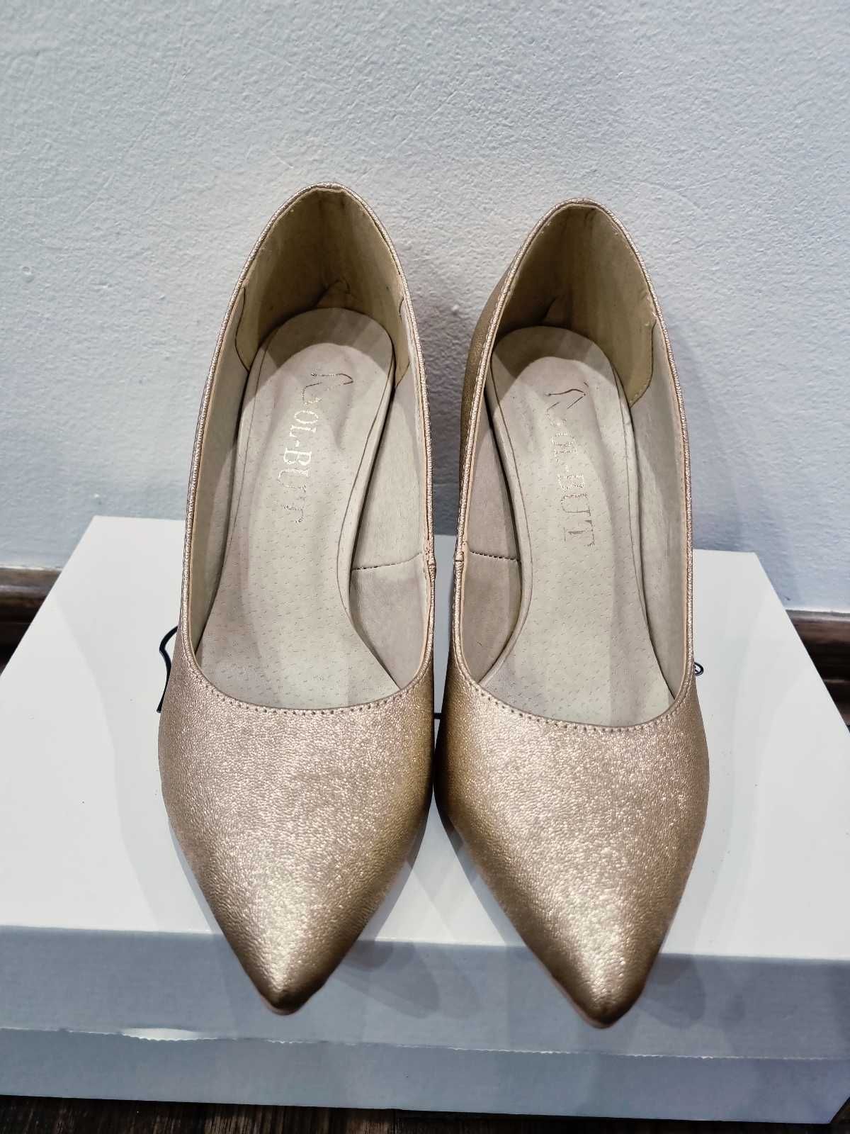 Złote eleganckie buty na słupku