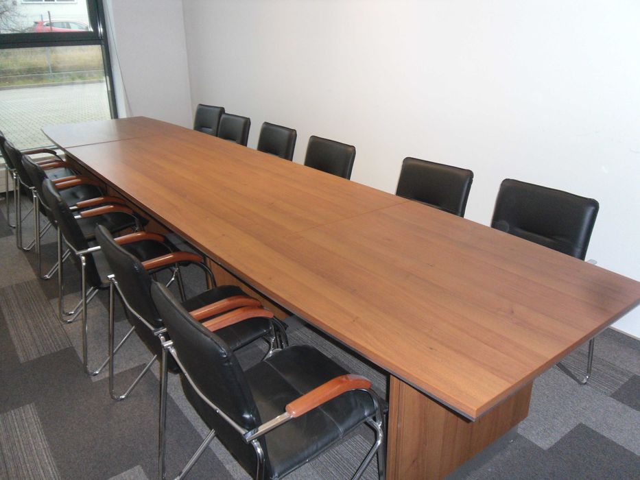 Duży stół konferencyjny z fotelami i szafką