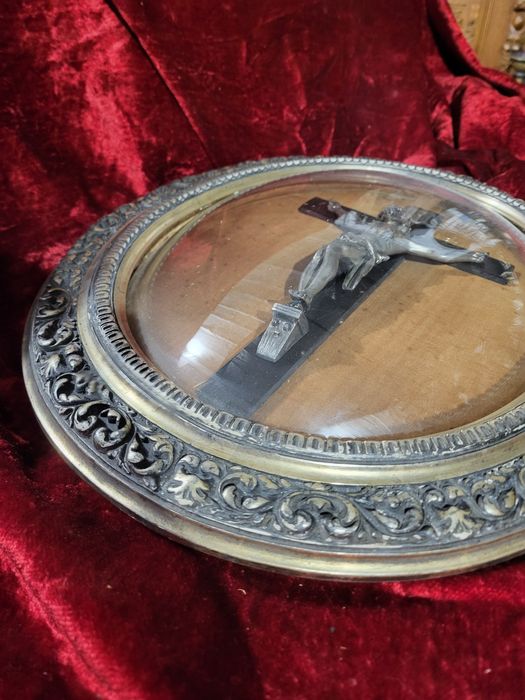 Stary krzyż w owalnej ramie za szkłem