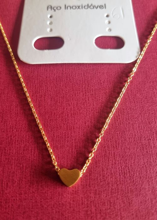 Colar dourado, em aço, com pequeno coração fixo. Tem extensor