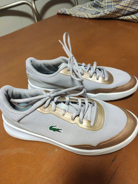 Ténis femininos,marca Lacoste. Cor bege e dourado