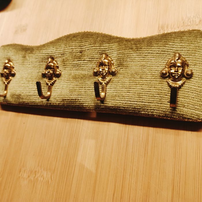 Wieszak z czterema hakami z motywem twarzy.