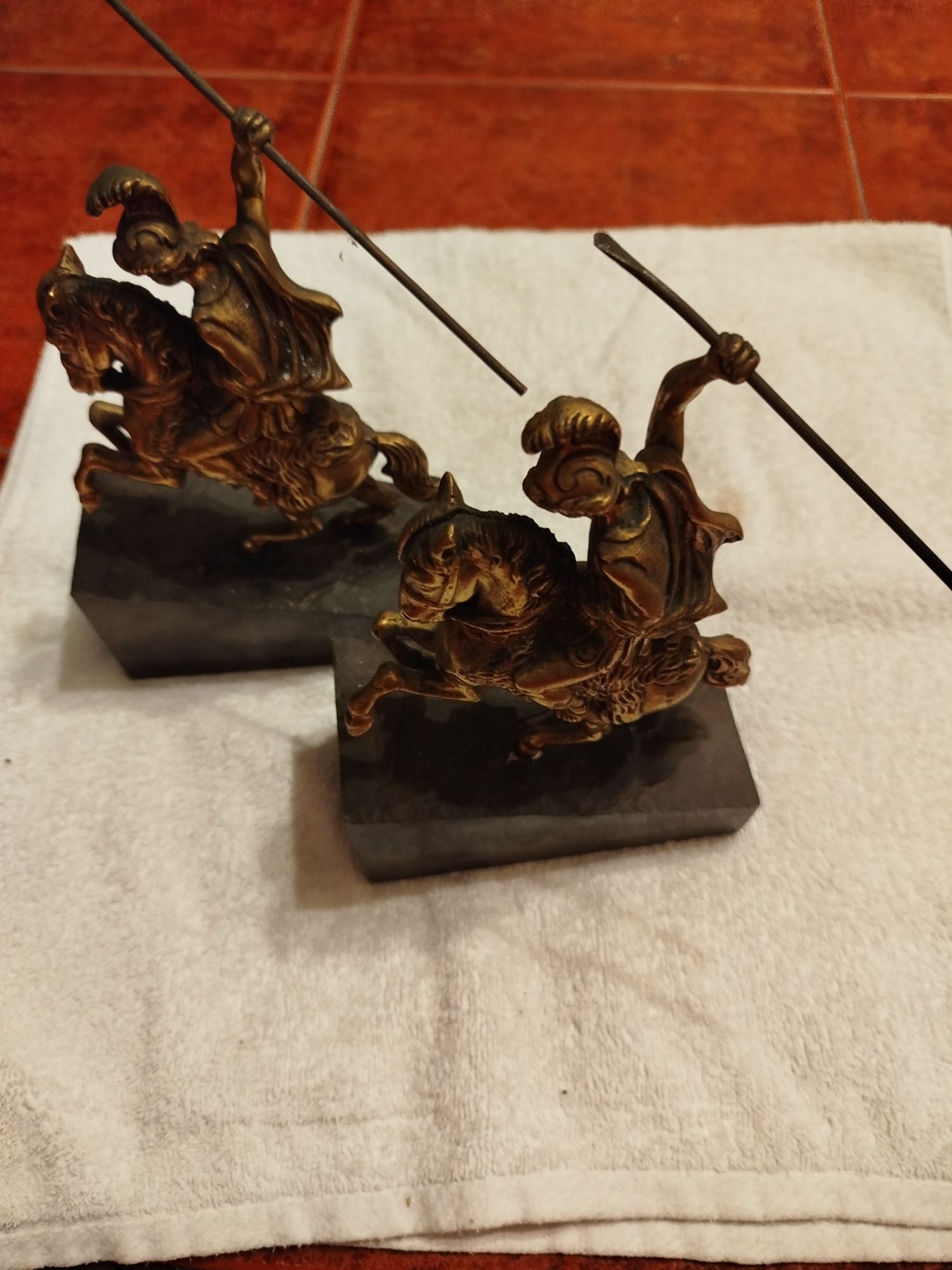 Duas esculturas antigas de um guerreiro em bronze e bases de mármore