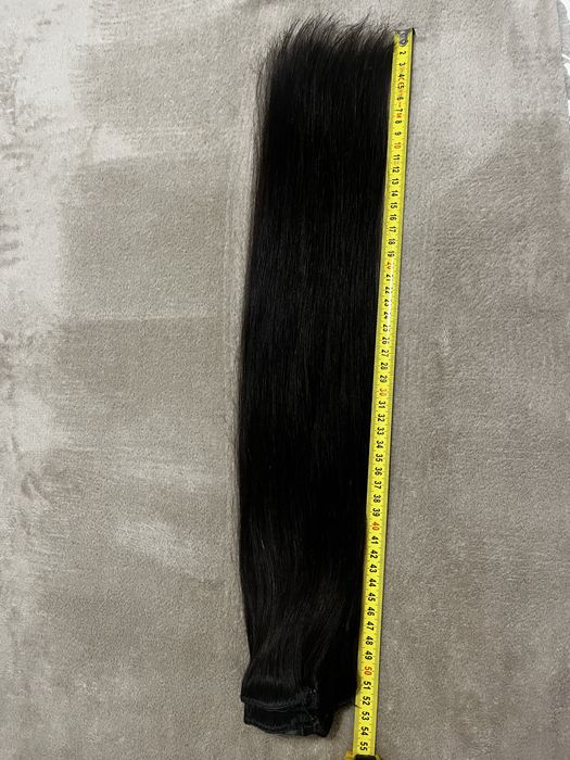 Extensões castanhas escuras de cabelo verdadeiro.