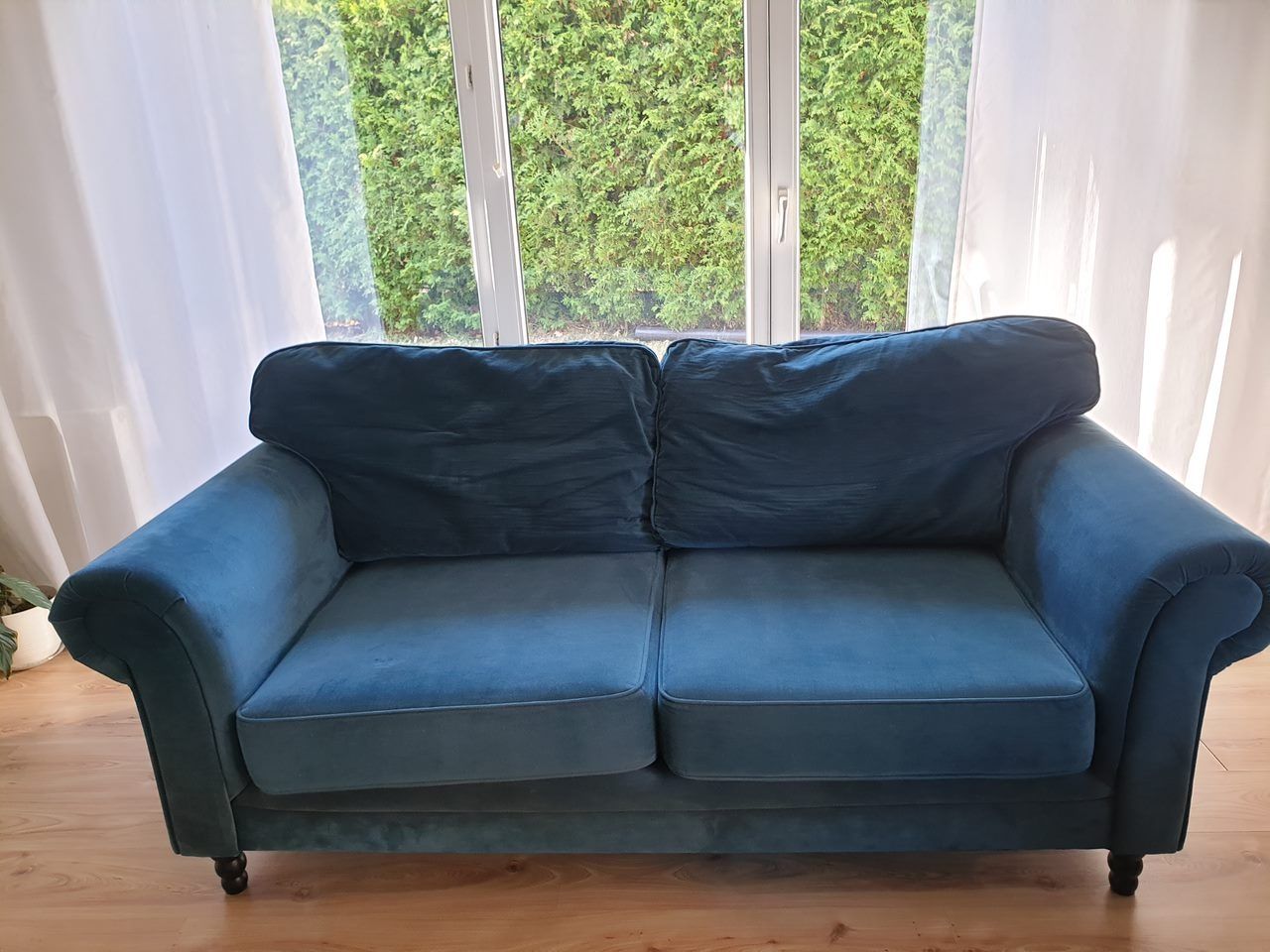 Nowoczesna sofa w szmaragdowym kolorze.