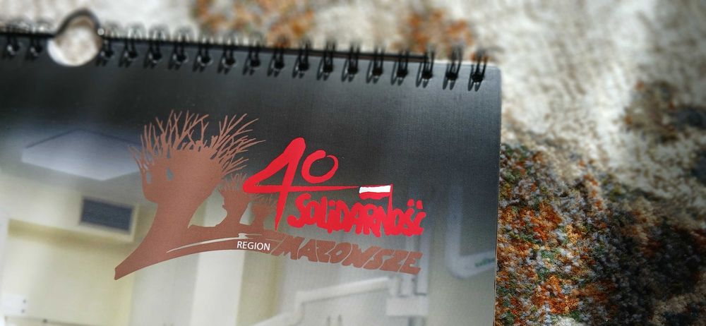 Gadżety związane z NSZZ „Solidarność”: kalandarz, biuletyn, film DVD