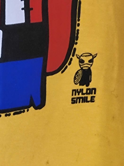 Żółta koszulka z kolekcji Nylon Smile, rozmiar M, nadrukiem bohaterów.