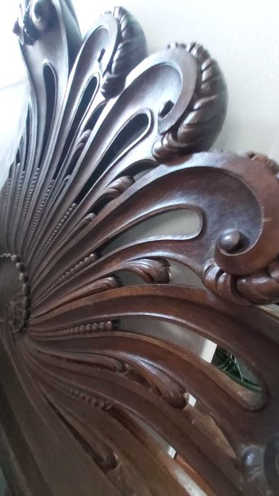 Cama casal de madeira maciça talhada com estrutura e cabecera.