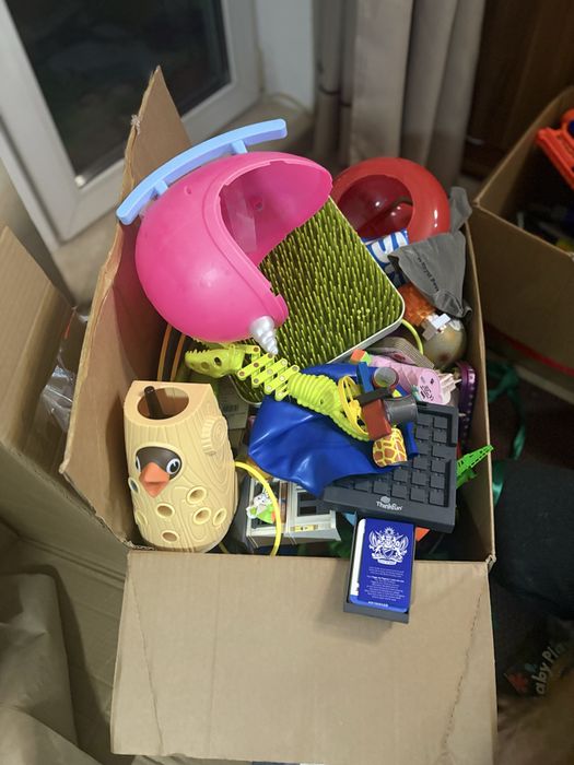 коробка, наполненная различными игрушками и предметами.
