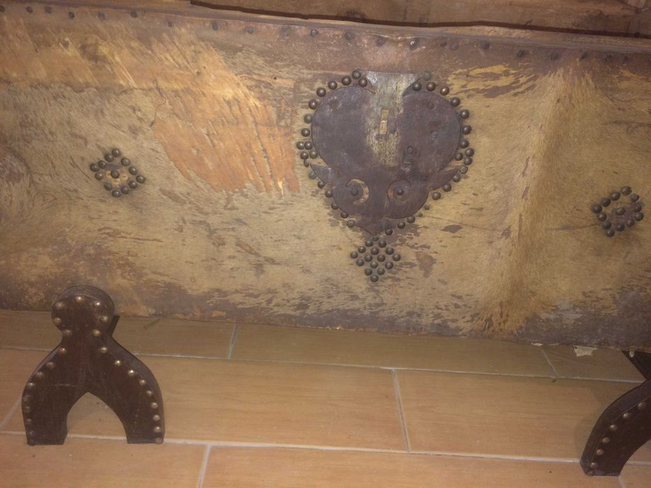 Arca antiga em pele de vaca com pés de madeira