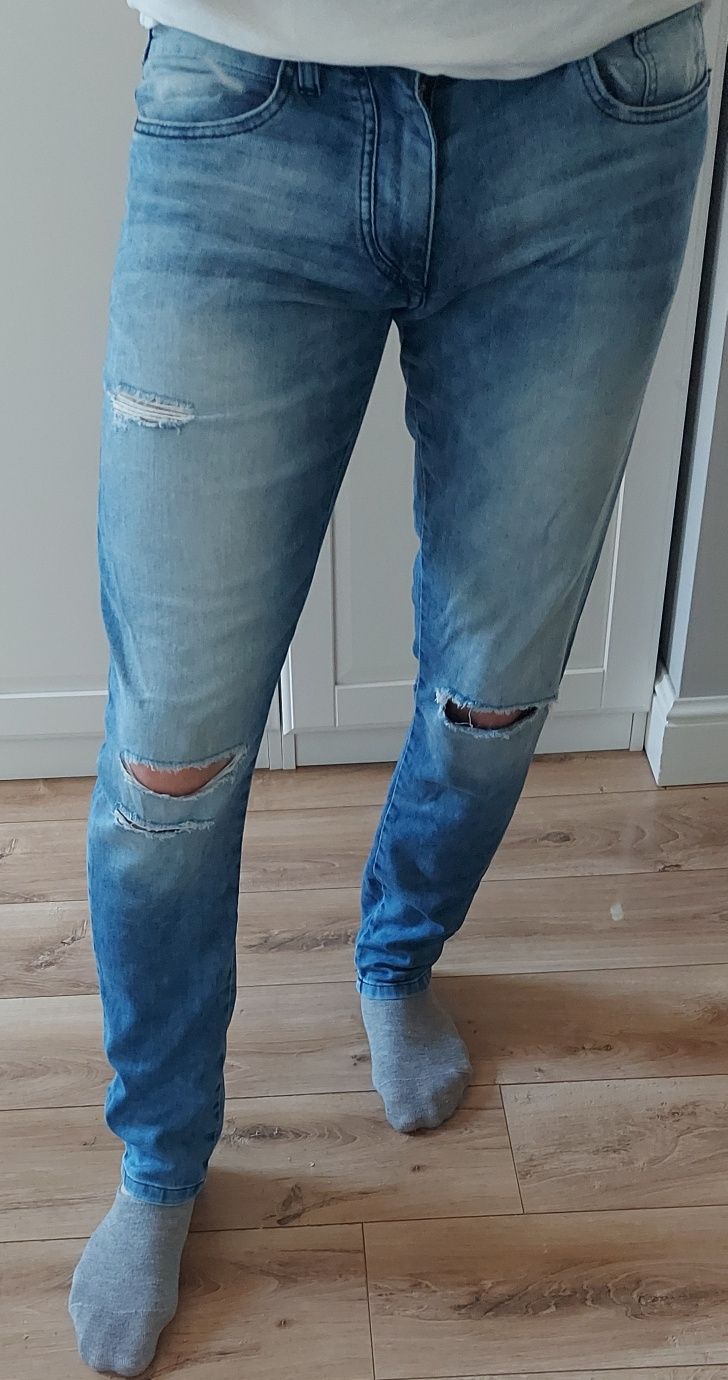 Jeansy Reserved 
Rozmiar 32/32 Niebieski jeans
z dziurami