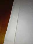 Lençol branco antigo com bainha aberta