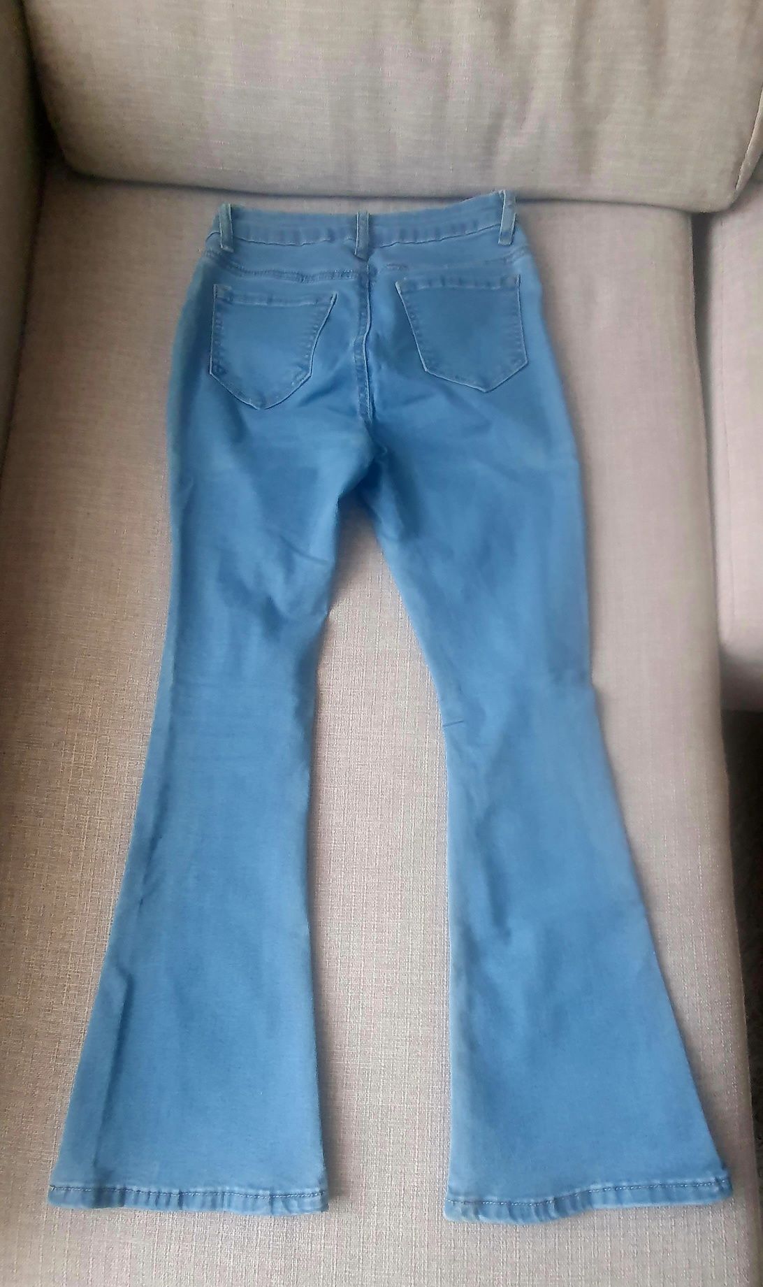 Calça de ganga cintura subida e boca de sino com abertura no fundo