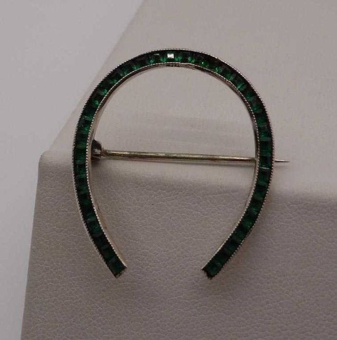 Antyczna srebrna broszka podkowa zielone szmaragdowe kamienie.