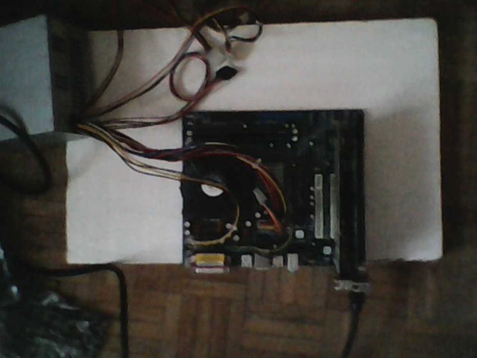Płyta główna ASRock, zasilacz, CD, kable, moduły.