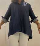 Blusa com pormenores de folhos, na manga, gola e escapulário, manga conprida. Muito elegante.