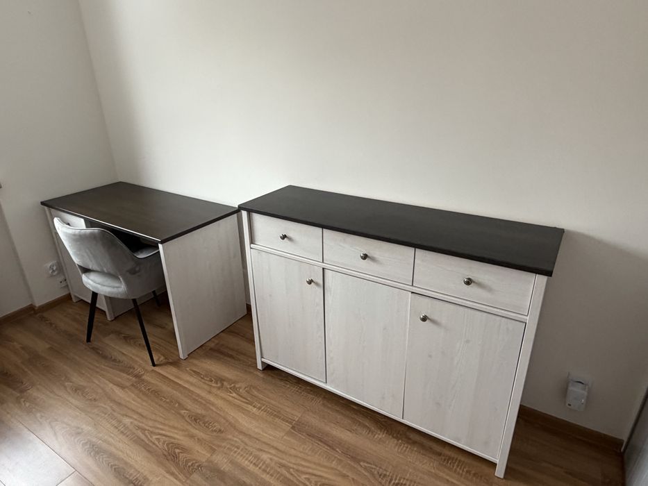 Zestaw mebli - białe drewno z ciemnym blatem.